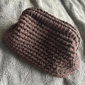 Brun stickad handväska - Virkat clutch/nessesär Virkad av mig Helt ny Virkad i ett  Bandgarn i bomull. Mått öppning ca 19x17 cm ca 13 cm hög 