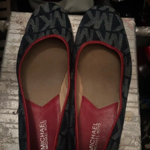 Michael Kors ballerinaskor denim röd - Snygga ballerinaskor från Michael Kors med denimblå ovandel och MK-mönster. Röd skinnliknande detalj vid öppningen och beige flätad kant runt sulan helt nya ❤️