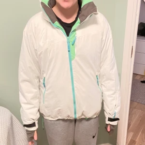 Vit vinterjacka från mammut  - En mammut vinterjacka i fint skick. Man kan både ha luvan ute eller sätta in den i kragen (bild 2 respektive 3) 