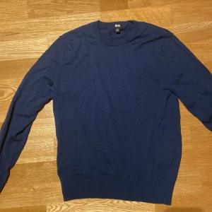 Mörkblå stickad tröja från Uniqlo - Snygg mörkblå stickad tröja från Uniqlo i storlek XS. Tröjan har rund hals och långa ärmar, perfekt för dig som gillar enkel och stilren design. Materialet är mjukt och skönt, passar bra till jeans eller chinos. Passar till dig som är 170 och kortare