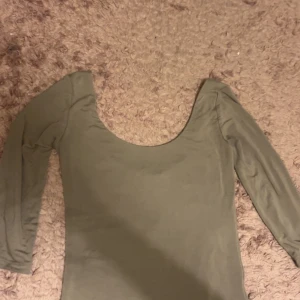 Olivgrön långärmad topp med djup urringning - Den är helt ny från gina tricot