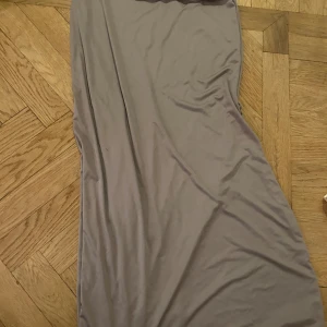 Beige långkjol från 157 - En stilren beige långkjol från 157 i mjukt och stretchigt material. Den har en enkel och rak passform, perfekt för dig som gillar minimalistisk stil. Färgen är diskret och passar till många olika looks.