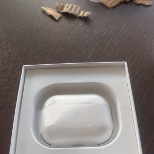 AirPods - Snygga och populära Apple AirPods i originalförpackning. Produkten ser oanvänd ut med skyddsplast kvar på laddningsetuiet. Perfekt för trådlös musik och samtal. Inga synliga defekter eller slitage, levereras i kartong.