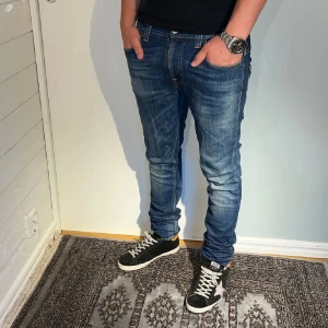 Nudie Jeans Tape Ted - Säljer ett par blå nudie jeans med fet fade. Storlek 31/32. Skick 9/10, använd någon gång. Perfekt till olika outfits. Hör gärna av er om ni har några funderingar!