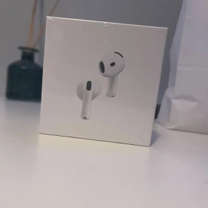 AirPods 4 - Helt nya Apple AirPods 4 med aktiv brusreducering. Levereras i obruten originalförpackning. Kompatibla med USB-C, Apple Watch och Qi-certifierade laddare. Perfekt för trådlös musik och samtal med hög ljudkvalitet.