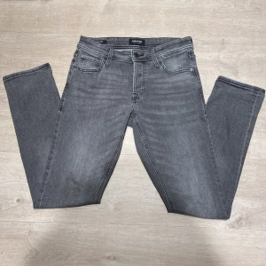 Jack & Jones jeans - Säljer ett par gråa jeans från Jack & Jones i modell slim glenn, jeansen är i mycket bra skick, storlek 29/32.