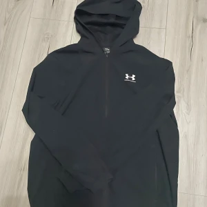Windbreaker från Under Armour - Svart windbreaker från Under Armour med vit logga på bröstet. Storlek S men passar även M