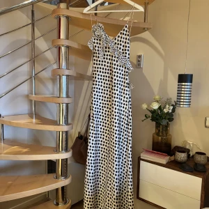 Zara polka dot dress open back S - Supersnygg långklänning från Zara i storlek S! Klänningen har smala axelband, omlottvolang över axeln och v-ringad front. Materialet är mjukt och glansigt. Öppen rygg och figurnära passform som ger en elegant siluett. Passar även bra med klack om man vill ha ett litet släp. Supersnygg men har tvätt aldrig kommit till användning. Köptes för 750kr. Säljer för 499 eller högsta bud💖
