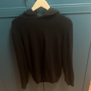 Kashmir hodie - En stilren mörkblå kashmir hodie med huva och långa ärmar. Perfekt för dig som gillar en enkel och clean look. Passar till det mesta och är superbekväm att slänga på sig när som helst. Den är från Oscar Jacobson och kostar original 1400, den är S men passar även M. 100% kashmir