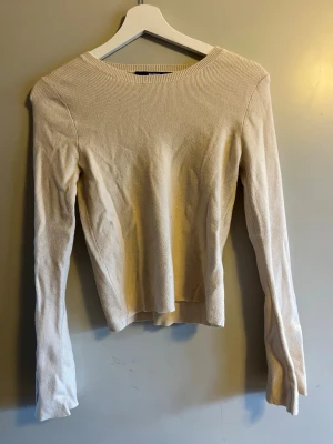 Beige stickad tröja från Bik Bok - Säljer en beige stickad tröja från Bik Bok i storlek S. Tröjan har rund halsringning och långa ärmar, med en ribbad struktur som ger en snygg och enkel look. Perfekt för dig som gillar stilrena och mjuka plagg. Vida armar!