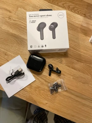 JAYS f-Six True Wireless - JAYS f-Six True Wireless hörlurar med touchkontroller, mikrofon och svettresistent design. Bluetooth, upp till 4 timmars batteritid per laddning och totalt 16 timmar med laddningsfodral. Komplett med extra öronkuddar, laddkabel och originalförpackning. Mindre yttre slitage på fodralet. Lite dåligt ljud i högra hörluren