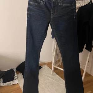 Levi's 514 mörkblå jeans bootcut - Mörkblå Levi's 514 jeans med klassisk bootcut-passform. Jeansen har fem fickor, kontrastsömmar och är tillverkade i slitstarkt denim. Perfekta för dig som gillar en tidlös look med lite vidare ben nertill.