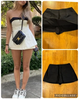 Svarta skorts med dragkedja M - Snygga svarta skorts med en stilren, A-linjeformad siluett och dold dragkedja bak. Skortsen har en kjolliknande framsida men är shorts under, vilket gör dem både bekväma och trendiga. Perfekt för dig som vill ha en chic look med extra rörelsefrihet.