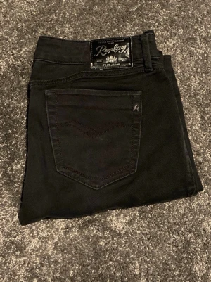 Svarta Replay Pearl jeans straight fit - Svarta jeans från Replay, modell Pearl, med klassisk femficksdesign och raka ben. Snygga detaljer som Replay-logga på bakfickan och metallmärke vid fickan. Jeansen är tillverkade i slitstarkt bomullsmaterial och har en stilren look med svarta sömmar.