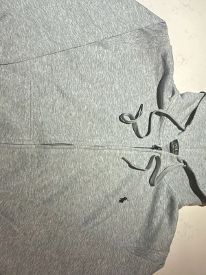 Grå Ralph Lauren hoodie - Fin hoodie i väldigt bra skick endast använd ett få tal gånger. Säljer för att den var för liten för mig