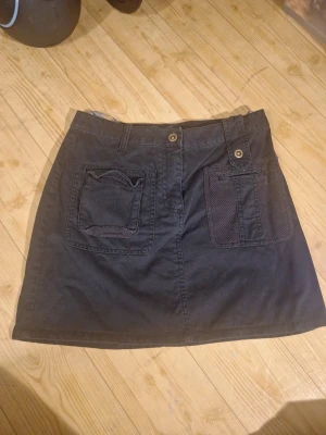 Svart jeanskjol - Svart jeanskjol från Mexx med coola detaljer som stora fickor fram och bak, aldrig använd men lite dammig (tvättas innan postning) midjemått cirka 35 cm och cirka 37 cm lång/rakt över