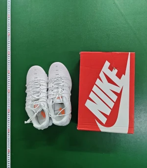  Air Max Plus vita sneakers - Nike Air Max Plus sneakers i helvit mesh och syntet med orange detaljer i sulan och Tn Air-logga på hälen. Skorna har snörning, platt sula och en sportig, chunky design som sticker ut. Perfekta för dig som gillar att synas och vill ha en modern look.