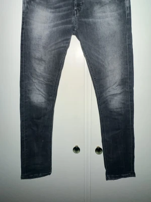Grå slimfit jeans från George, stl 31 - Snygga grå jeans från George i slimfit-modell. De har en smal passform och klassisk femficksdesign. Jeansen är tillverkade i stretchigt denimmaterial som sitter tajt och bekvämt. Perfekt för dig som gillar en modern och stilren look.