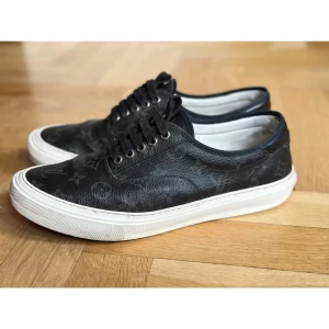 Louis Vuitton Trocadero sneakers - Louis Vuitton Trocadero sneakers – strl 43 (EU) Snygga sneakers i Monogram Eclipse canvas från Louis Vuitton. Svart läderdetalj vid hälen och vit sula.   Skick: Använda, men i helt okej skick (se bilder)  Ingår: – Original dustbag – Kvitto – Kuvert för kvitto från LV