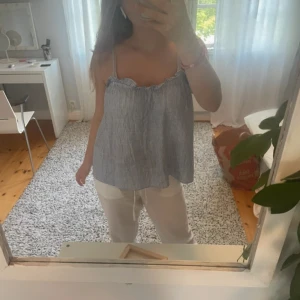 Randig blå linnetopp med tunna band - Superfin blå- och vitrandig blus från HM. Säljer då den är för stor för mig, storlek S men skulle uppskatta den som en M. Justerbara band! Skriv för fler bilder☀️