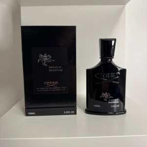 Creed Aventus Absolu 100ml parfym - Lyxig parfym från Creed, Aventus Absolu, i en elegant svart flaska med silverdetaljer och ikonisk logga. Flaskan rymmer 100ml och har en stilren, exklusiv design som verkligen sticker ut på hyllan.
