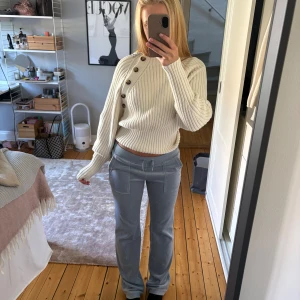 Ljusblå mjukisbyxor Juicy Couture XS - Ljusblå mjukisbyxor från Juicy Couture med raka ben och bred resår i midjan. Byxorna har stora fickor fram och bak med knappdetaljer. Mjukt och stretchigt material som är riktigt skönt att ha på sig.