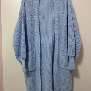 Ljusblå stickad kofta med fickor - Supermysig lång och oversized ljusblå stickad kofta med stora fickor framtill. Håller en riktigt varm, perfekt nu för hösten och vintern🍂 Aldrig använt då den inte kommit till användning, i storlek S, nypris 299kr✨ Pris går att diskuteras🤗