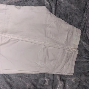Vita raka jeans 2 för 1 - Säljer ett par fräscha vita jeans från Levis med klassisk femficksdesign och raka ben. Jeansen har en stilren look med diskret Levis-lapp bak i midjan. Perfekta för dig som vill ha en clean och enkel stil.