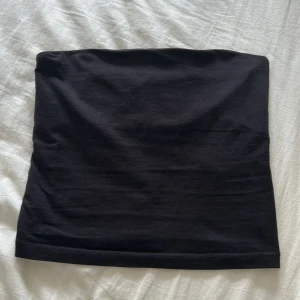 Svart bandeau tubtopp i bomull - Enkel svart croppad bandeau tubtopp i mjuk bomull. Från början ett linne från Gina Tricot med tunna spagetti band som klippts av till en tubtopp. 
