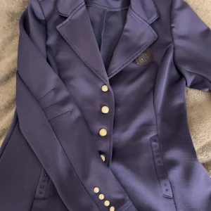 Tävlingskavaj  - ”Ny tävlings kavaj” använd en gång. Super fin marinblå glittrig kavaj.  Storlek 38😊 Nypris 1599kr  Säljs för 700kr +frakt.