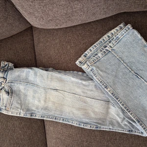 Ljusblå jeans från lager 157  - Säljer ett par ljusblå jeans från 157 Paris med dubbla knappar i midjan och klassisk femficksdesign. Jeansen har raka ben och är tillverkade i mjukt denimtyg. Perfekta för dig som gillar en avslappnad och stilren look.