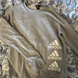 Collagetröja - Grå collagetröja från Adidas. Sparsamt använd. Storlek 13/14y men passar mig som har S bara ett den är lite tight. Tvättar allt innan, skriv för mer bilder eller om du har några frågor.💞