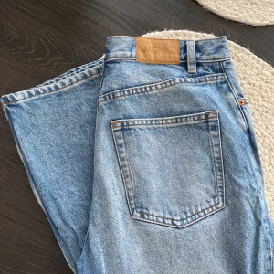 Monki ljusblå raka jeans Monki - Ljusblå jeans från Monki med klassisk femficksmodell och raka ben. Medelhög midja och tydliga kontrastsömmar. Jeansen är tillverkade i bomullsdenim och har en snygg vintagekänsla. (Är 177cm lång)
