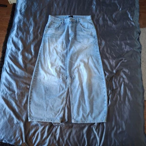 Wide ljusblå jeans från ASOS DESIGN - Ljusblå jeans från ASOS DESIGN med riktigt breda ben och klassisk femficksdesign. Hög midja och raka, loose fit-ben ger en avslappnad vibe. Tillverkade i jeansmaterial med snygga sömdetaljer både fram och bak.