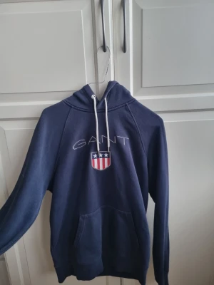 Gant hoodie  - Blå Gant hoodie för 299kr                                                              Storlek - M. (Passar även S)                                                 Nypris cirka 1400 kr.                                               Väldigt bra skick, säljer eftersom den inte passar mig längre.
