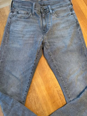 Levi's 511 grå slim jeans - Säljer ett par grå Levi's 511 slimmade jeans i storlek W29 L32. Klassisk femficksmodell med snygg tvätt och diskret slitning. Passformen är slim och raka ben. Vid frågor är det bara att skriva! Kom med bud om priset inte passar!