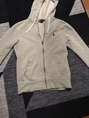 Grå tröja från Ralph Lauren  - Fin tröja från Ralph Lauren. Har ett litet hål vid armen men syns inte när man har på den