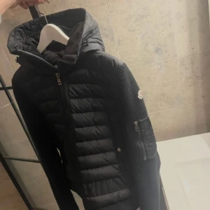 Svart moncler jacka  - Moncler Cardigan i fint skick säljes, NFC Scan och allt funkar Skick 7.5/10 med ett hål i ärmen som inte syns & storlek Medium