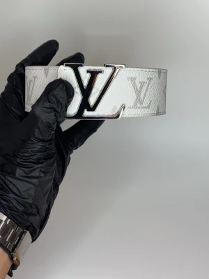 L bälte vit monogram - Helt nya oanvända bälten i olika märken, modeller och färger! Kommer bra packat samt med ett litet verktyg som du enkelt kan göra hål med ifall du skulle behöva det. Vi postar allas ordrar inom 24h för att du ska få ditt paket så fort som möjligt! Använd helst instabox men PostNord funkar också! 