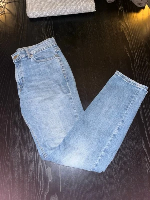  ljusblå jeans - jeans i ljusblå tvätt med raka ben och hög midja. Femficksmodell med knappgylf och  patch bak i midjan. Tillverkade i slitstarkt bomullsjeansmaterial. Perfekta för en avslappnad och tidlös look.