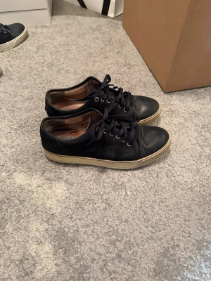 Svarta Lanvin sneakers med snörning - Tjena, säljder dessa snygga lavin skor! De är köpte i Göteborg! Skicket är 6-7  finns inga håll ellee så men de syns ej att de är andvända när de sitter på! Går ner i pris vid snabb affär!