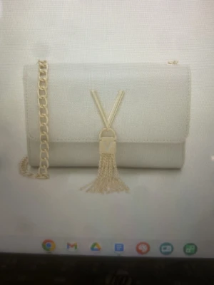 Beige axelväska från Valentino - Köpte för 2000 Säljer en stilren beige axelväska från Valentino med guldfärgad kedja och logga framtill. Väskan har en elegant rektangulär form och är tillverkad i skinnliknande material. Perfekt för dig som gillar lyxiga detaljer och snygg design.