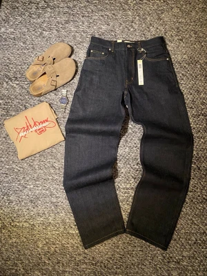 Selvedge jeans - Säljer dessa raw selvedge jeans av straight/baggy passform, herrmodell. De har en djup mörkblå färg som kommer slitas riktigt snyggt vid användning. Nypris ligger på 1700kr. Aldrig använda med prislapp kvar. Skicka gärna ett bud!  Fråga om du vill ha mått eller fler bilder!  Storlek 30/32  100% bomull #vintage #hiphop #swag #drip #jeans #selvedge #skateboarding #fashion #pinterest #retro #aesthetic #höst #fall #autumn #vinter #washed #denim #affliction #raw #straight #baggy #nudie #levis 