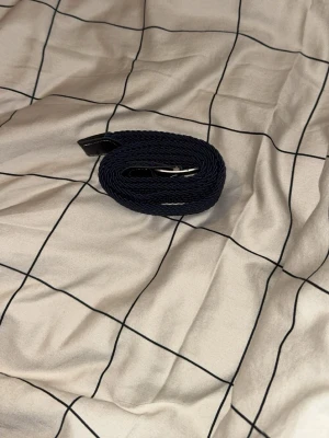 Mörkblå flätad bälte med svart läder  - Snyggt mörkblått grisch bälte med svart läder som du behöver nu när grisch tiderna kommer igång så behöver du detta bältet köp nu för 130kr 