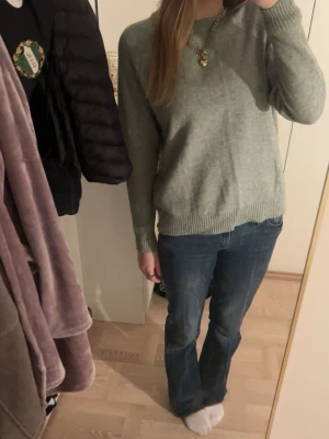 ljusgrön stickad tröja från ONLY - Mysig ljusgrön stickad tröja från ONLY med rund halsringning och ribbade muddar vid ärmslut och nederkant. Perfekt för lager-på-lager och enkel att matcha med jeans eller kjol. Klassisk modell med normal passform och långa ärmar.