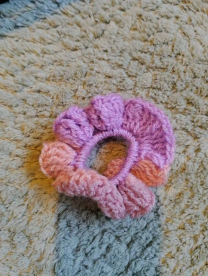 Handgjord virkad scrunchie i rosa och lila  - Superfin handgjord virkad scrunchie i lila och rosa med volangkant. Perfekt för att ge din frisyr en söt och färgglad touch. Mjuk och stretchig, passar både till uppsatt hår och som accessoar runt handleden. Virkad av mig!