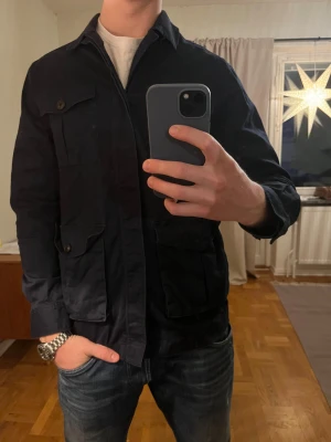 Mörkblå Riley safarijacka  - Säljer denna sjukt snygga safarijackan från Riley⭐️ Färgen är mörkblå och storleken är M✅ Den har inga defekter och skicket är utomordentligt🙌🤝 Sjukt najs passform och passar perfekt till hösten🍁🙌 Tveka inte på att höra av er dig vid minsta fråga eller fundering😊