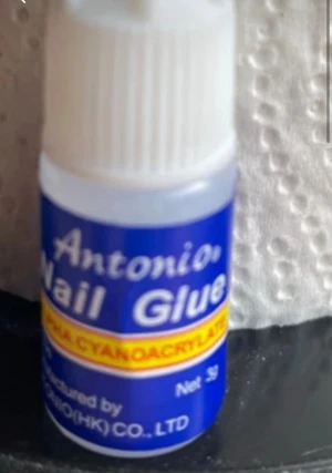 Antonio Nail Glue 3g - Antonio Nail Glue i en liten plastflaska med vitt lock och blå etikett. Perfekt för att fästa lösnaglar snabbt och enkelt. Innehåller 3g och är smidig att ta med i väskan. Formulan är baserad på cyanoakrylat för starkt fäste.