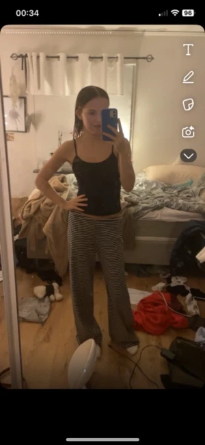 Randiga vida byxor med snörning - Säljer ett par svarta och vita randiga byxor med snörning i midjan. Byxorna har en loose och wide passform med raka ben och är riktigt sköna att ha på sig. Perfekta för dig som gillar avslappnad stil och vill ha något som sticker ut lite extra.