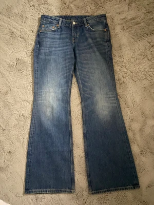 Weekday Nova Low Slim Bootcut Jeans - Snygga blå jeans från Weekday i modellen Nova Low Slim Bootcut. De har låg midja och bootcut-ben. Jeansen är lite urtvättade som ger en snygg detalj vid benen!❤️